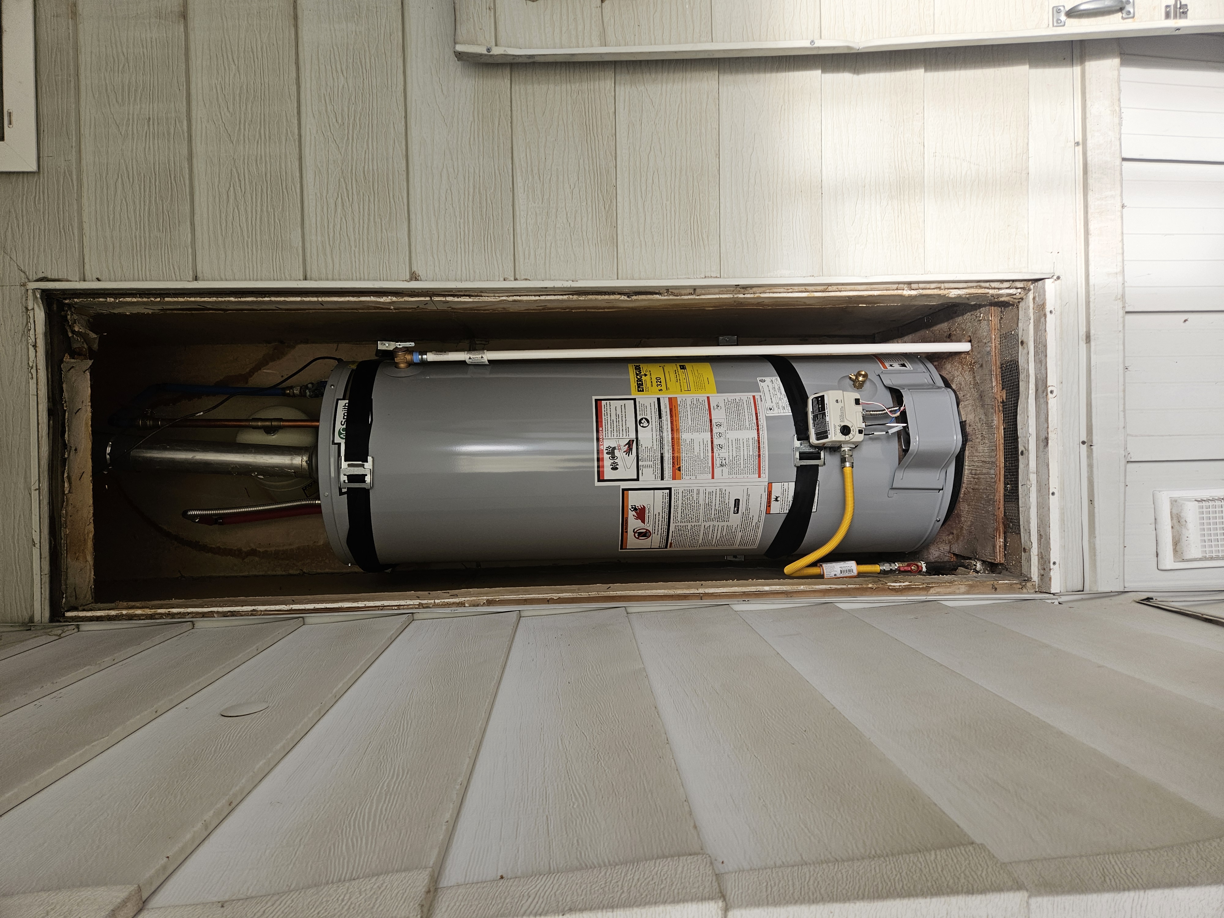 A.O. Smith gas water heater installed in an exterior closet of a mobile home in Taylorsville, Utah